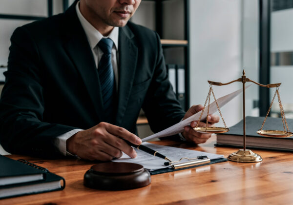 legals-id-corporate-law Business executives signing a corporate partnership agreement assisted by Legals ID